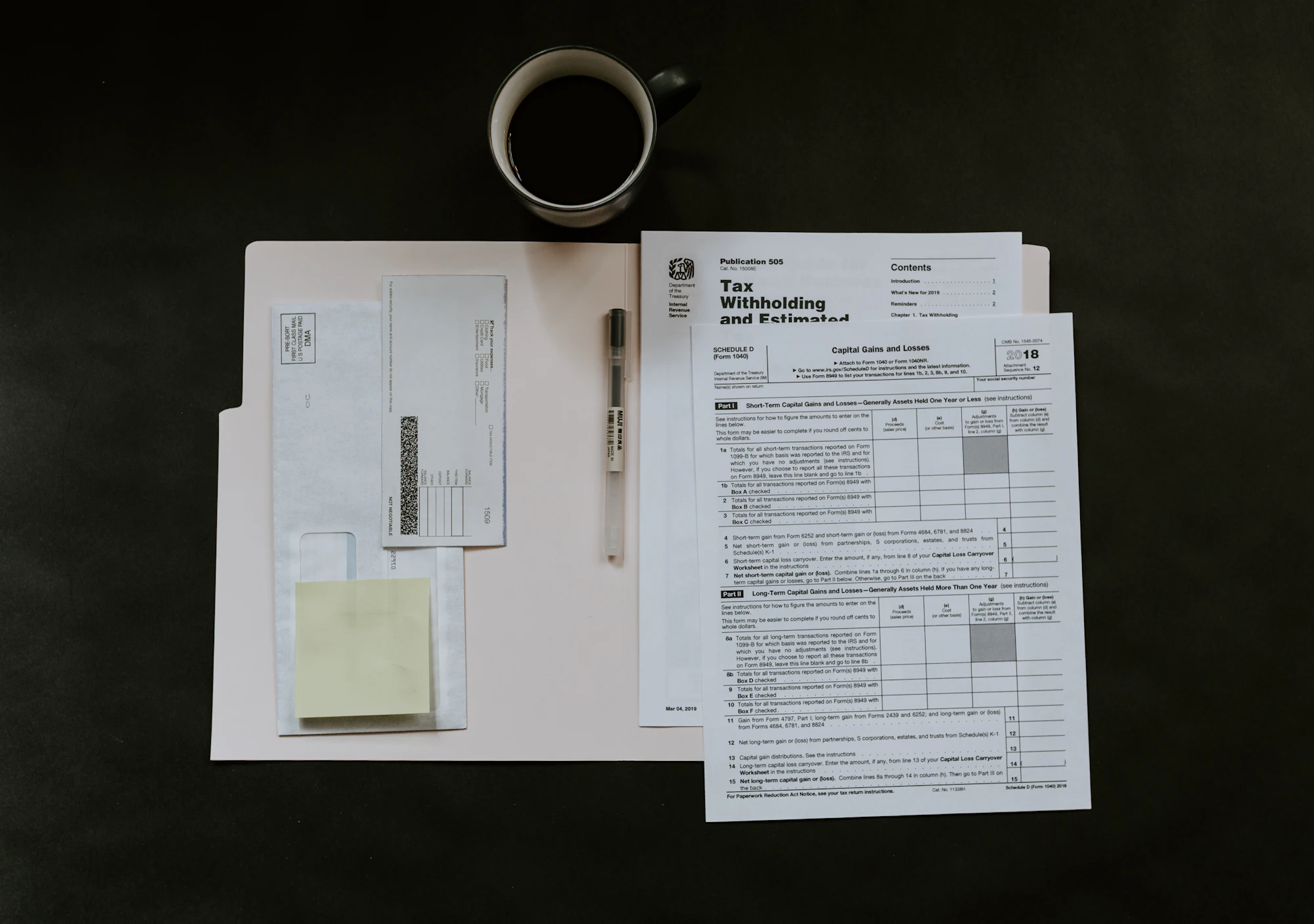 Tax forms and a cup of coffee on a dark desk