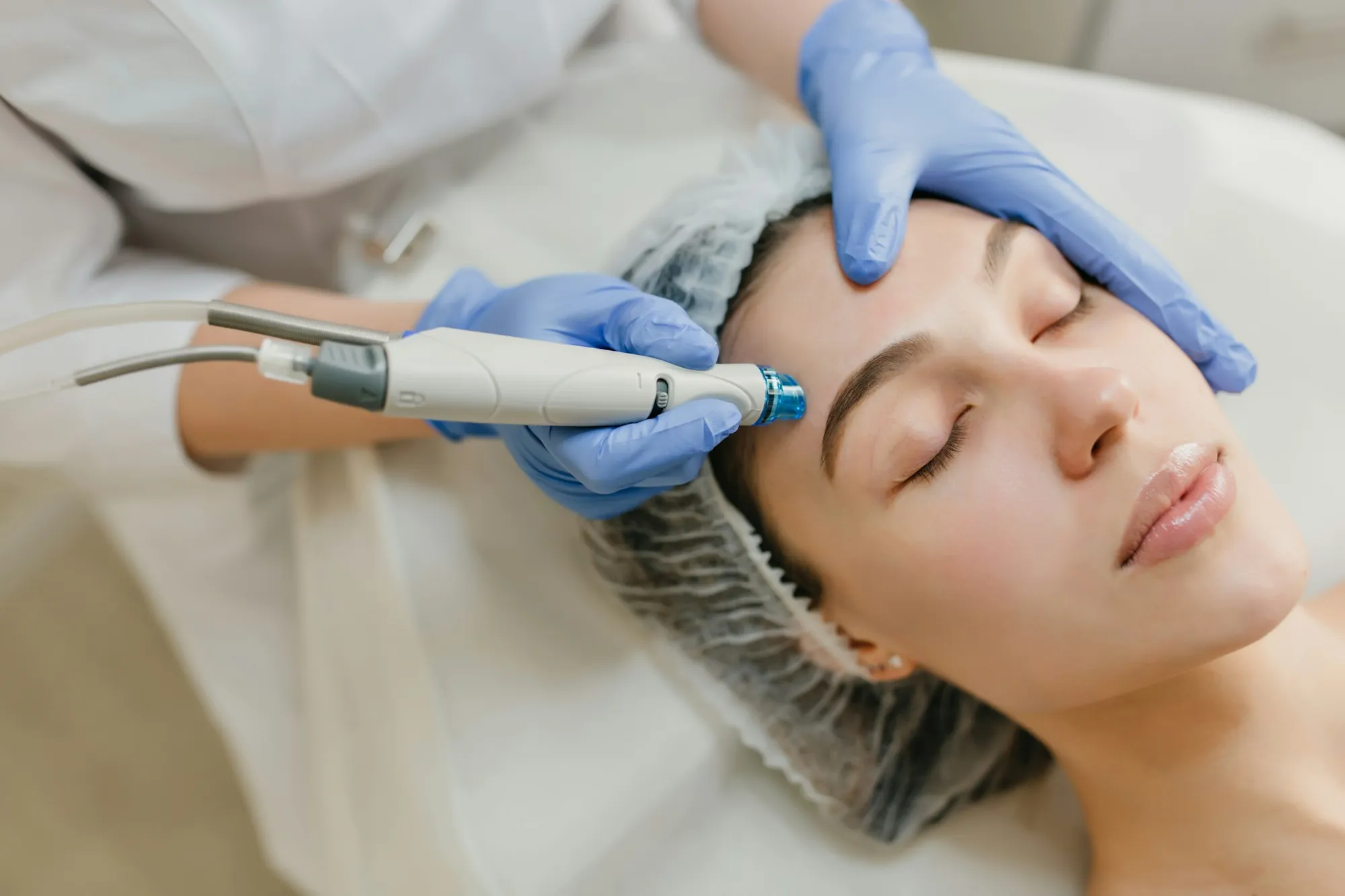 A provider in gloves giving a client a facial treatment