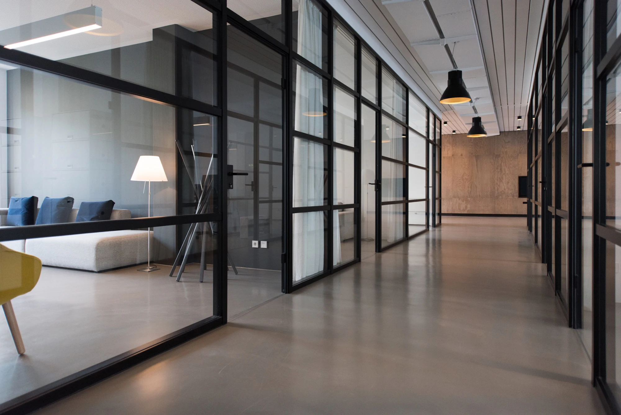 A bright hallway between glass office doors